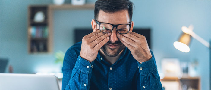 a guy with stress rubbing both his eyes